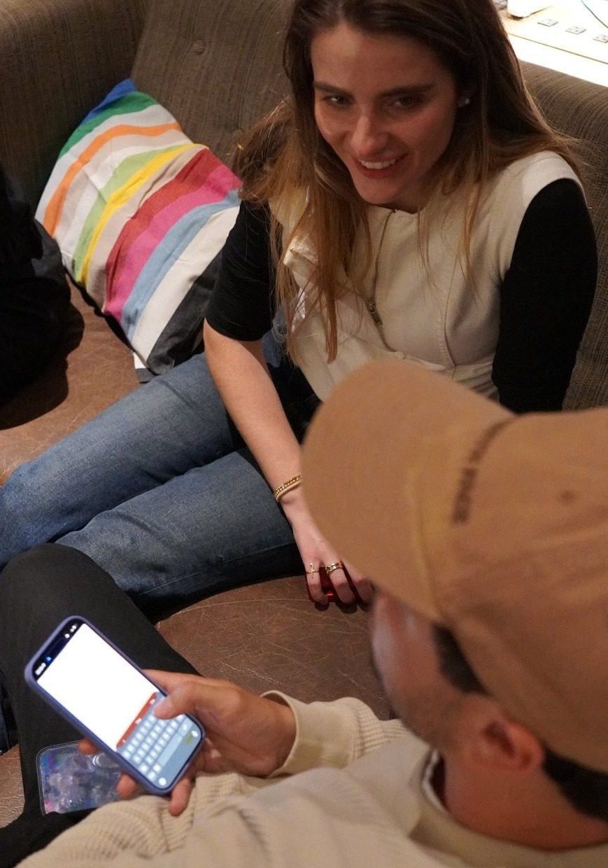 Two Oyster members on a couch, one showing the other something on their phone