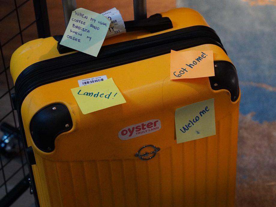 A suitcase covered in handwritten notes reading “Landed!” and “Welcome” at an Oyster event