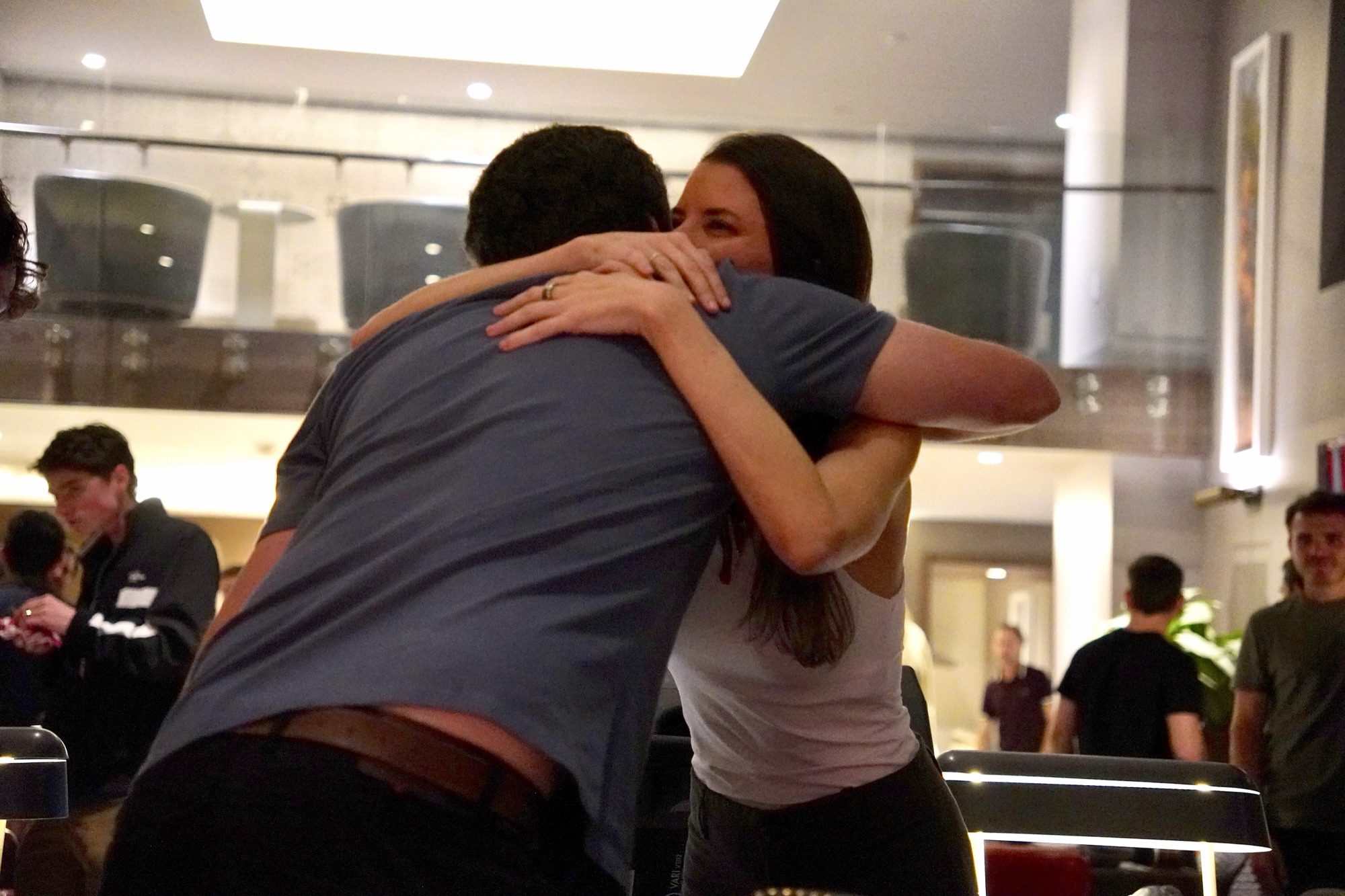 Two friends hugging at an Oyster gathering